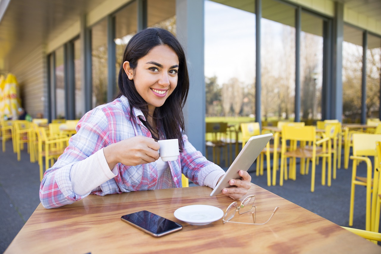 girl-4928767_1280 girl smiling on a tablet while sipping coffee